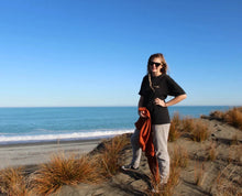 Load image into Gallery viewer, Zoey on beach wearing Origin Organic Cotton Joggers in a small. Certified, ethically made in factory powered by solar and wind energy