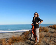Load image into Gallery viewer, Zoey on beach wearing Origin Organic Cotton Joggers in a small. Certified, ethically made in factory powered by solar and wind energy

