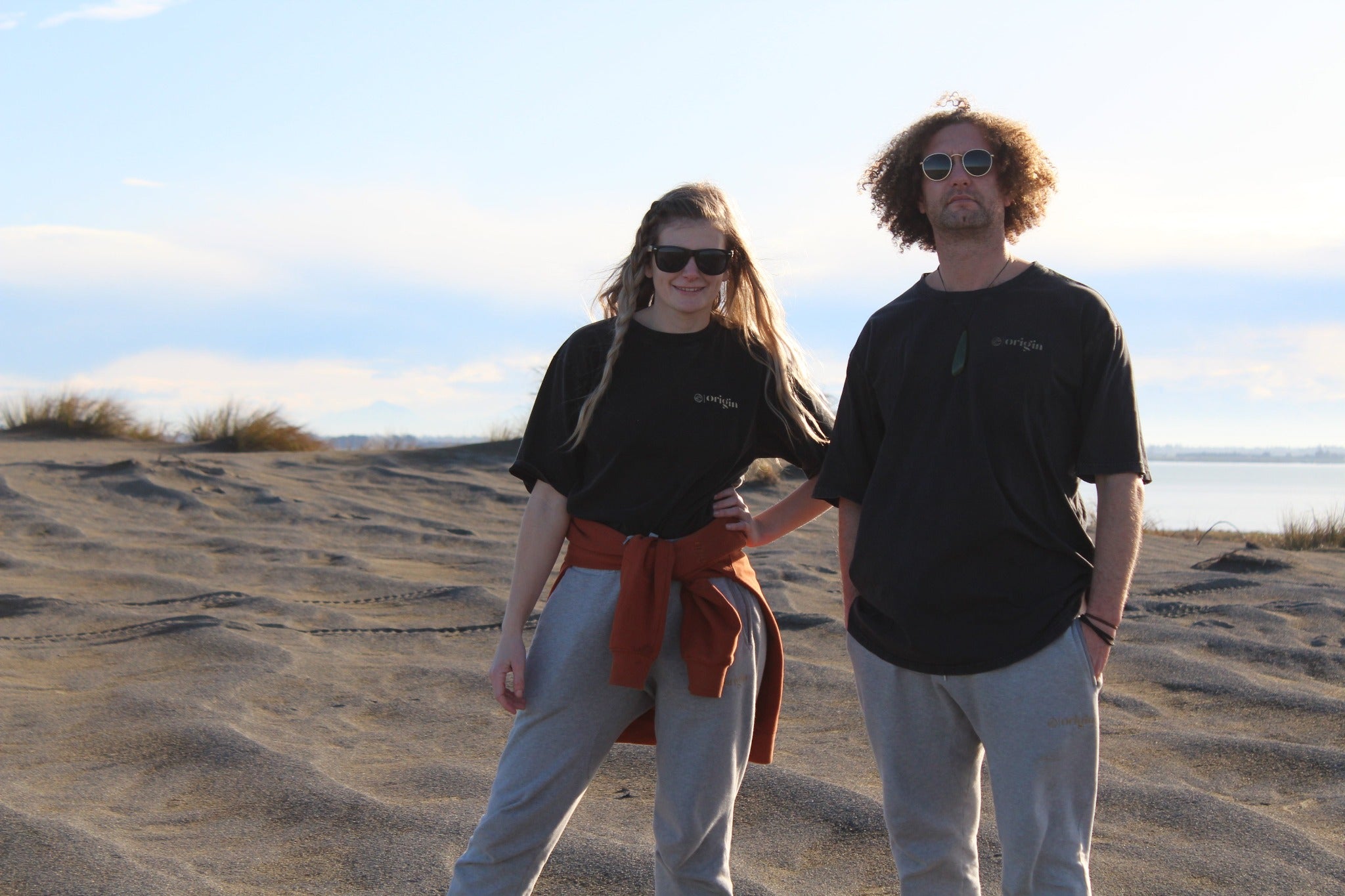 Zoey and Maru on beach wearing Origin Organic Cotton Joggers, Maru in a large ,Zoey in a small. Certified, ethically made in factory powered by solar and wind energy